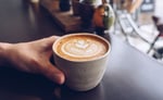 omnia hand holding coffee cup cappuccino
